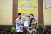 LLDIKTI Wilayah VII Jawa Timur, Prof. Dr. Dyah Sawitri,(kanan) saat menyerahkan Salinan Keputusan Menteri Pendidikan Tinggi, Sains dan Teknologi Republik Indonesia, Nomor: 605/B/0/2025 kepada Ketua PPLP-PT PGRI Sumenep, Sunarjo(kiri) (za - garudajatim.com) 