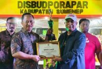 Kepada Bappeda Sumenep, Arif Firmanto(kiri) saat menerima penghargaan Best Booth dari Kepala Disbudporapar, Moh. Iksan(kanan) di acara Madura Night Vaganza (Istimewa - garudajatim.com) 
