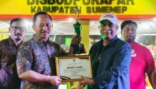 Kepada Bappeda Sumenep, Arif Firmanto(kiri) saat menerima penghargaan Best Booth dari Kepala Disbudporapar, Moh. Iksan(kanan) di acara Madura Night Vaganza (Istimewa - garudajatim.com) 