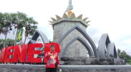 Kepala Disbudporapar Sumenep, Mohamad Iksan, saat memakai blangkon dan batik di tugu keris (Istimewa - garudajatim.com) 