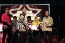 Kepala Bidang Pelayanan Pendaftaran Penduduk Disdukcapil Sumenep, Wahasah, saat menerima penghargaan inovasi daerah yang diberikan oleh Plt Sekda R. Achmad Syahwan Effendy (Za - garudajatim.com)