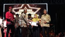 Kepala Bidang Pelayanan Pendaftaran Penduduk Disdukcapil Sumenep, Wahasah, saat menerima penghargaan inovasi daerah yang diberikan oleh Plt Sekda R. Achmad Syahwan Effendy (Za - garudajatim.com)