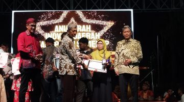 Kepala Bidang Pelayanan Pendaftaran Penduduk Disdukcapil Sumenep, Wahasah, saat menerima penghargaan inovasi daerah yang diberikan oleh Plt Sekda R. Achmad Syahwan Effendy (Za - garudajatim.com)