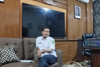 Kepala Dinas Sosial Kabupaten Sumenep, Mustangin, saat diwawancarai di ruangannya (Za - garudajatim.com)