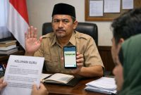 Foto ilustrasi Kepala SPPG Legung Barat, Sumenep, Yayasan At-ta’awun, Adam Ramadhan Rifa’i, saat merespon wawancara media dengan singkat (Ris - garudajatim.com)