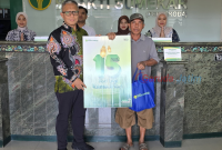 Direktur Utama BPRS Bhakti Sumekar, Hairil Fajar, saat melaksanakan aksi berbagi kepada nasabah pengunjung pertama di kantor (Za - garudajatim.com)