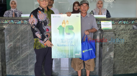 Direktur Utama BPRS Bhakti Sumekar, Hairil Fajar, saat melaksanakan aksi berbagi kepada nasabah pengunjung pertama di kantor (Za - garudajatim.com)