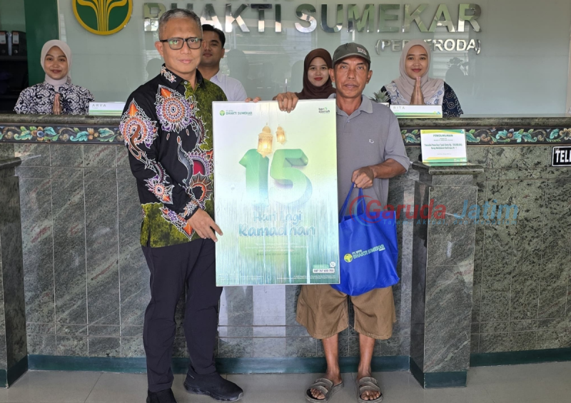 Direktur Utama BPRS Bhakti Sumekar, Hairil Fajar, saat melaksanakan aksi berbagi kepada nasabah pengunjung pertama di kantor (Za - garudajatim.com)