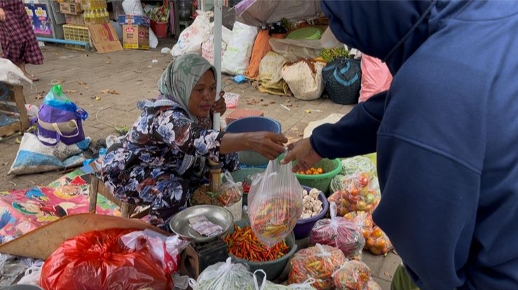 Penjual cabai rawit di pasar anom Sumenep saat melakukan transaksi jual beli (Za - garudajatim.com)