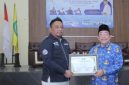 Ketua IWO Sumenep, Imam Mustain Ramli, saat menyerahkan penghargaan kepada Wakil Bupati Imam Hasyim (Za - garudajatim.com)