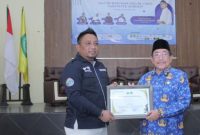 Ketua IWO Sumenep, Imam Mustain Ramli, saat menyerahkan penghargaan kepada Wakil Bupati Imam Hasyim (Za - garudajatim.com)