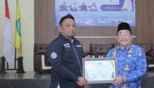 Ketua IWO Sumenep, Imam Mustain Ramli, saat menyerahkan penghargaan kepada Wakil Bupati Imam Hasyim (Za - garudajatim.com)