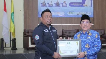 Ketua IWO Sumenep, Imam Mustain Ramli, saat menyerahkan penghargaan kepada Wakil Bupati Imam Hasyim (Za - garudajatim.com)