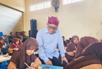 Direktur Utama PT BPRS Bhakti Sumekar, Hairil Fajar(menggunakan belangkon) saat mengunjungi siswa (Istimewa - garudajatim.com)